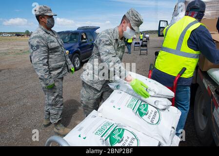 Die New Mexico National Guard Airmen laden als Reaktion auf COVID-19, die Coronavirus-Pandemie beim Feed Tampa Bay-Projekt am 14. Mai 2020 in Rock Springs, New Mexico, eine Lebensmittellieferung ein. Stockfoto