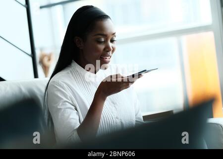 Schwarze Frau, Die Das Mobiltelefon Für Voice Mail Verwendet Stockfoto