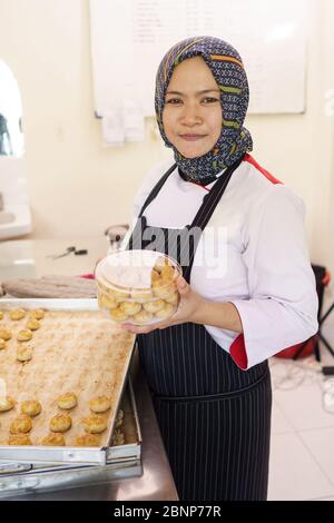 Stolz muslimische Frau hausgemachte Bäckerei. Backen einige Ananas Torte Kuchen Stockfoto