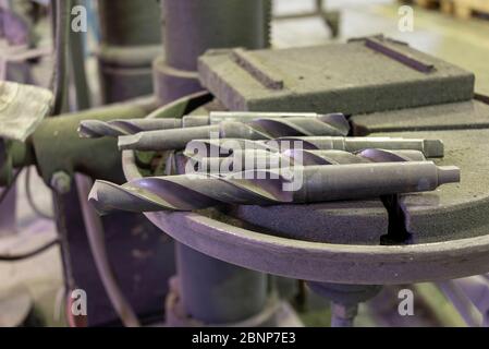 Bohren liegt auf einem Bohrtisch in einer Werkstatt. Stockfoto