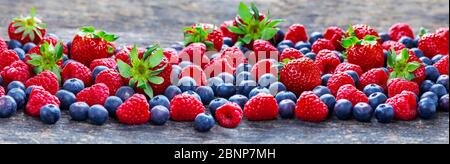 Obst auf Steinplatte, Erdbeeren, Himbeeren, Heidelbeeren Stockfoto