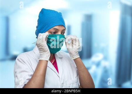 Nahaufnahme einer medizinischen Arbeiterin, Krankenschwester, die eine Atemschutzmaske aufsetzt, um vor dem Coronavirus zu schützen, Covid-19 Pandemic. Stockfoto