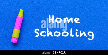 Homeschool. Wörter oder getippter Text auf blauem Brett. Mit gelbem Buntstift. Bildungskonzept. Stockfoto