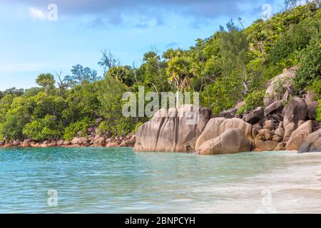 Granitfelsen und tropische Vegetation am Strand von Anse Lazio, auf der Insel Praslin, auf den Seychellen, Stockfoto