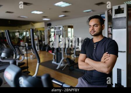 Junger bärtiger Inder, der Cardio-Übungen im Fitnessstudio macht Stockfoto
