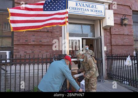 New York, Usa. Mai 2020. Mitglieder der US Army National Guard verteilen Nahrung und andere Dinge an die Menschen in einer Speisekammer inmitten der Coronavirus-Pandemie (Covid-19) im Stadtteil Queens in New York City. Quelle: SOPA Images Limited/Alamy Live News Stockfoto