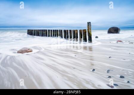 Groyne und Felsbrocken am Ostseestrand, wolkiger Himmel, stürmisches Meer, bei Rostock, Mecklenburg-Vorpommern, Deutschland Stockfoto