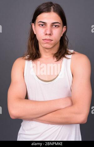 Junger schöner androgyner Mann mit langen Haaren Stockfoto