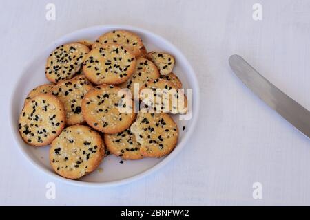 Knusprige Brote mit Sesam und Kreuzkümmel/leckere Haferflocken auf weißem Teller Stockfoto