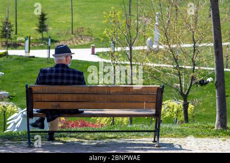 Maskierter Mann auf Bank sitzend Stockfoto