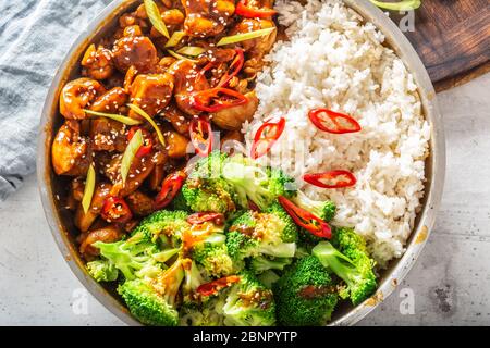 Chinesisches Gericht mit Hühnereintopf, gedämpftem Reis und Brokkoli, Chili und Sesam. Stockfoto