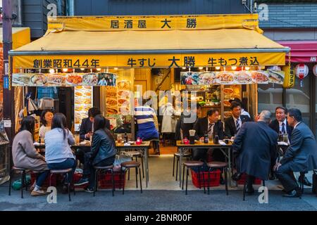 Japan, Honshu, Tokio, Asakusa, Gruppe japanischer Geschäftsleute und Touristen, Die Getränke in Der Traditionellen Snack Bar genießen Stockfoto