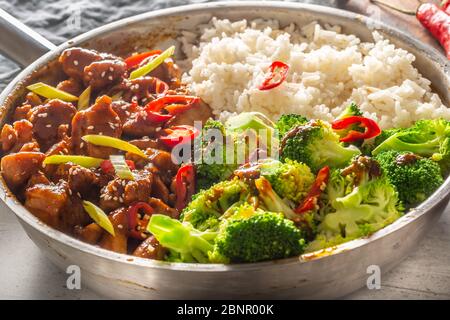 Würziges Teriyaki-Huhn mit gedämpftem Brokkoli und Reis in einem Topf. Stockfoto