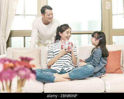 Junge asiatische Frau, die ein Geschenk von Tochter am Tag der Mutter Stockfoto