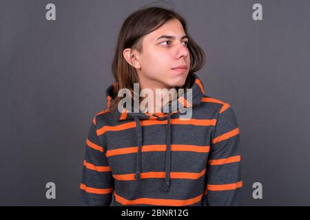 Junger schöner androgyner Mann mit langen Haaren Stockfoto