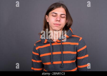 Junger schöner androgyner Mann mit langen Haaren Stockfoto