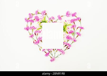 Herz aus rosa Blumen und Papier Karte isoliert auf weißem Hintergrund. Flach liegend, Draufsicht. Stockfoto