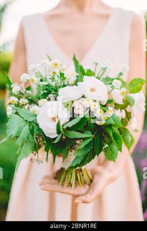 Junge Frau Floristin hält in Händen Blumen Blumenstrauß. Romantischer Moment Stockfoto