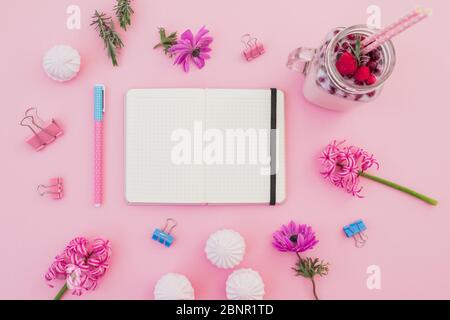 Beeren Smoothie mit Strohhalmen, Marshmallow, Tagebuch, Stift und rosa Blüten auf rosa. Flaches Lay. Draufsicht Stockfoto