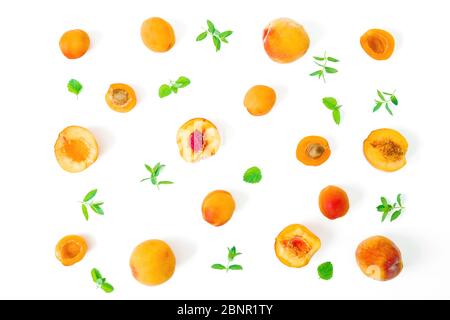 Reife Pfirsiche mit Blättern auf weißem Hintergrund isoliert. Sommerliches Fruchtmuster. Draufsicht. Flaches Lay Stockfoto