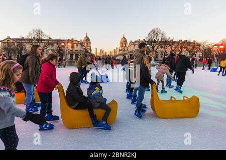 England, London, Greenwich, Erwachsene und Kinder Eislaufen im Queens House Ice Rink Stockfoto