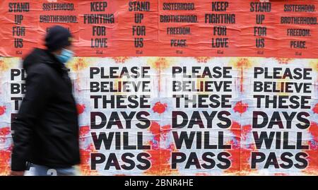 Peking, China. April 2020. Ein Mann geht an Plakaten vorbei, die Menschen zum Glauben ermutigen, während des Coronavirus-Ausbruchs in London am 30. April 2020. Kredit: Han Yan/Xinhua/Alamy Live News Stockfoto