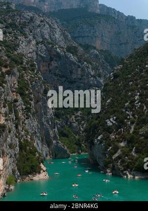 Touristenboote unter steilen Kalksteinfelsen am Eingang der Gorges du Verdon in den Alpes de Haute Provence, Südfrankreich Stockfoto