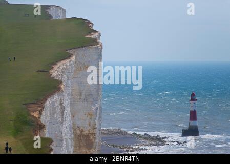 Vertikale Kreidefelsen mit Meeresklippen, Beachy Head Leuchtturm und Spaziergängern im South Downs Natural Park Stockfoto