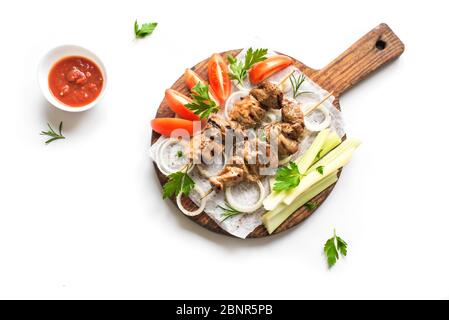 Gegrillte Schweinespieße auf Holzbrett isoliert auf weißem Hintergrund, Draufsicht. Fleisch, Schweinefleisch, Huhn oder putenschisch Kebab mit Gemüse, Tomatensauce, Stockfoto
