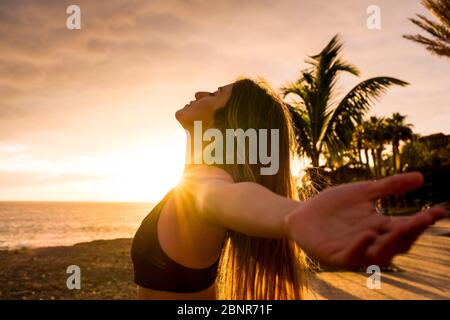 Gesunde Menschen leben genießen Sonnenuntergang und Fitness-Aktivität allein - schöne Frau spüren die Sonne und den Ozean Sauerstoff nach dem Training Sport-Session-Klasse - offene Arme und Freiheit atmen Stockfoto