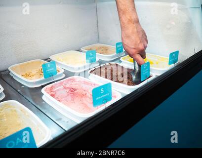 Männliche Hand schaufeln Schokoladeneis in einem Eisgeschäft Stockfoto