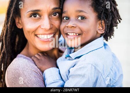 Porträt des Familienpaares Mutter und Sohn schwarz afro ethnische Rasse Lächeln und Blick auf die Kamera - Konzept der Vielfalt und alleinerziehende Mutter mit kleinen Kindern - Glück und Freude Konzept mit Liebe - Fokus auf Kinder Augen Stockfoto