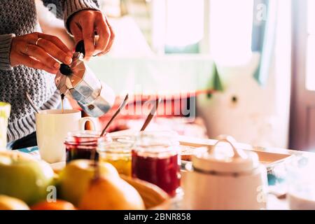 Nahaufnahme der kaukasischen Hände, die morgens traditionelle Kaffee-Dor-Frühstückszeit servieren und durchführen - helles Bild mit Essen und Getränken zu Hause Stockfoto