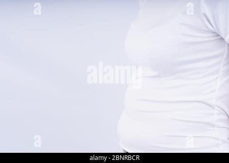 Nahaufnahme Frau zeigt übermäßige Bauchfett, übergewichtigen Bauch auf weißem Hintergrund. Gewichtsverlust, Ernährung Lebensstil, gesundes Konzept. Stockfoto