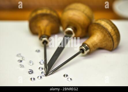Schmuckherstellung. Werkzeug zum Befestigen von Diamanten auf weißem Hintergrund mit Diamanten. Stockfoto