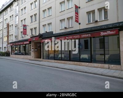 Geschlossenes Restaurant wegen Corona-Virus mit einer autofreien und menschenleeren Straße in der Innenstadt von München Stockfoto