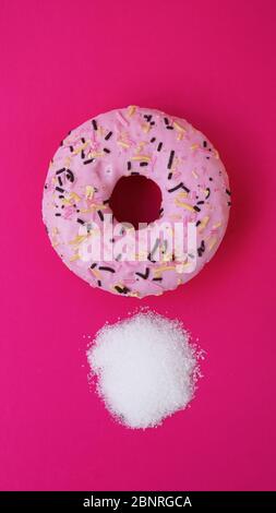 Donut mit Zucker auf rosa Hintergrund. Süße Donuts. Diät und ungesunde Ernährung Konzept. Stockfoto