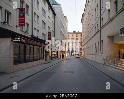 Geschlossenes Restaurant wegen Corona-Virus mit einer autofreien und menschenleeren Straße in der Innenstadt von München Stockfoto