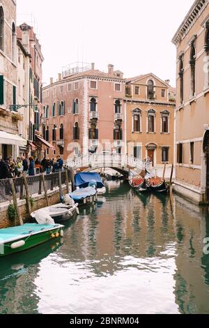 Venedig, Italien - 04. oktober 2019: Eine Menge Touristen geht durch die Straßen von Venedig, in Italien, in der Nähe eines engen Kanals zwischen Gebäuden. Kleine Bogenschützen Stockfoto