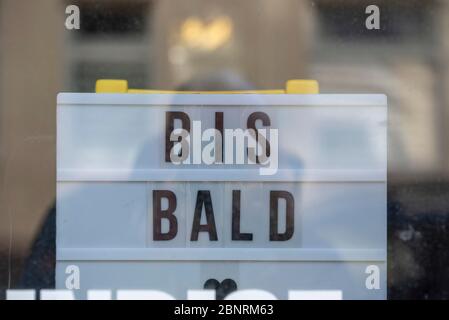 In einem Schaufenster steht ein Schild mit der Aufschrift 'bis BALD'. Der dazugehörige Bräunungssalon ist aufgrund der Koronenkrise geschlossen. Stockfoto