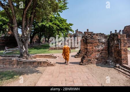 Ayutthaya, Bangkok / Thailand - 9. Februar 2020: Mönch in orangefarbener Kleidung und er geht, Foto von buddhistischen Mönchen auf der Rückseite Stockfoto