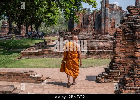 Ayutthaya, Bangkok / Thailand - 9. Februar 2020: Mönch in orangefarbener Kleidung und er geht, Foto von buddhistischen Mönchen auf der Rückseite Stockfoto