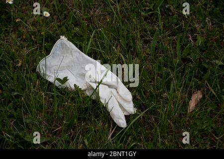 Sheffield UK – Mai 13 2020: Verlassene weiße Gummihandschuhe auf dem Boden entsorgt, Schutzausrüstung wird während des Coronavirus Covid-19 pande zu Abfall Stockfoto