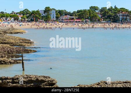 Saint-Palais-sur-Mer, Frankreich: An einem überfüllten Strand im Herzen dieses beliebten Badeorts an der französischen Atlantikküste können die Menschen die Sonne genießen. Stockfoto