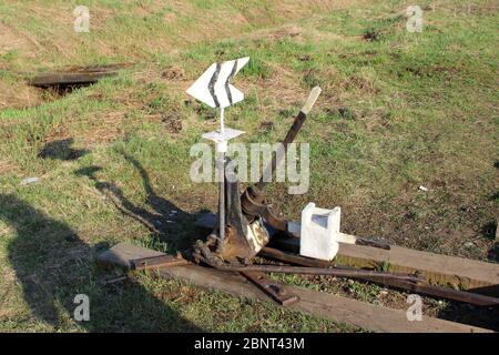 Eisenbahnpfeil in schwarz mit Hebel und Zeiger in Russland. Die Vorrichtung für den Schienenverkehr an Kreuzungen für Züge. Technisches Element der Bahnindustrie. Stockfoto