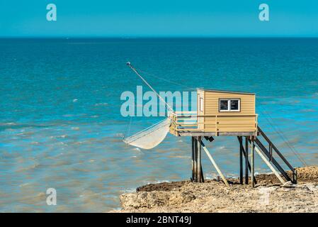 Saint-Palais-sur-Mer, Frankreich: Eine traditionelle Fischerhütte auf Stelzen mit einem für diese Gegend typischen carrelet-Fischernetz, das auf dem Felsen gebaut wurde. Stockfoto