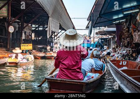 Ratchaburi, Damnoen Saduak / Thailand - 11. Februar 2020: Name dieses Ortes Damnoen Saduak Floating Market. Verkäuferin schrubbe das Boot mit ihrem Hut Stockfoto