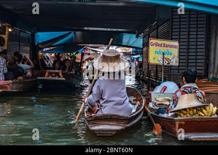 Ratchaburi, Damnoen Saduak / Thailand - 11. Februar 2020: Name dieses Ortes Damnoen Saduak Floating Market. Verkäuferin schrubbe das Boot mit ihrem Hut Stockfoto