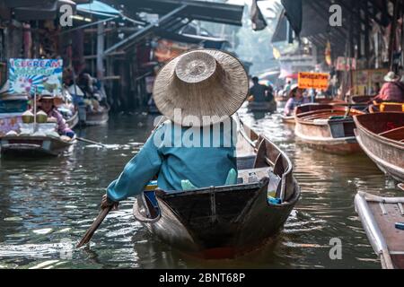 Ratchaburi, Damnoen Saduak / Thailand - 11. Februar 2020: Name dieses Ortes Damnoen Saduak Floating Market. Verkäuferin schrubbe das Boot mit ihrem Hut Stockfoto