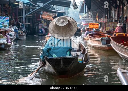 Ratchaburi, Damnoen Saduak / Thailand - 11. Februar 2020: Name dieses Ortes Damnoen Saduak Floating Market. Verkäuferin schrubbe das Boot mit ihrem Hut Stockfoto